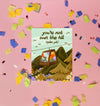 Greeting card with a mountain scene and a little dog riding a gondola. At the top the text says 'you're not over the hill (quite yet)'.