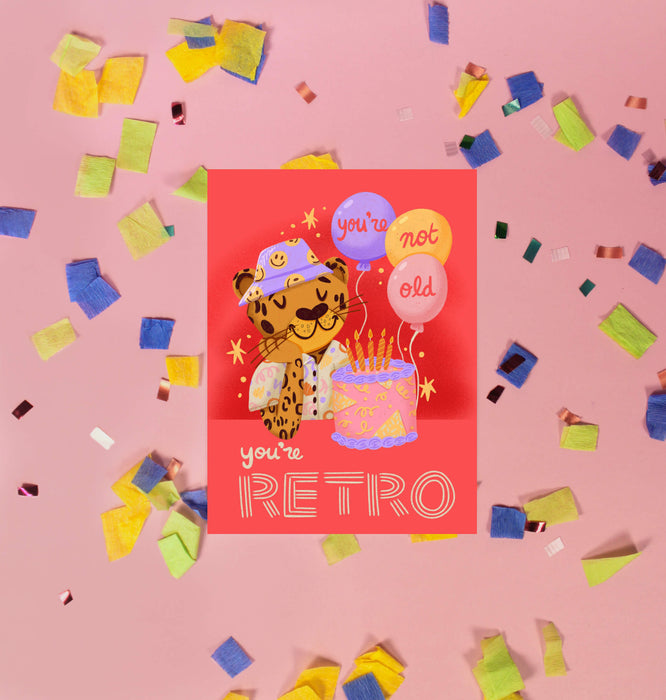 Greeting card with a retro-themed illustration of a leopard and balloons on a red background.