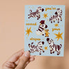 Graduation greeting card featuring stars and joyful zebras surrounding a white horse having it's stripes painted on by a little mouse.