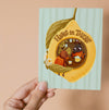 Greeting card with two insects inside a lemon, with text 'Hang in There'.
