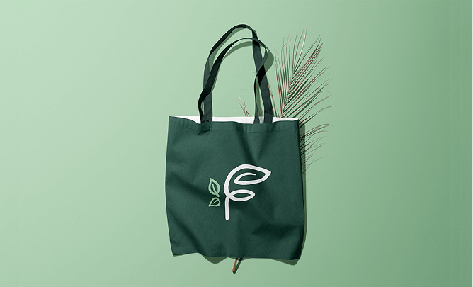 Green tote bag with a white leaf logo on a green background