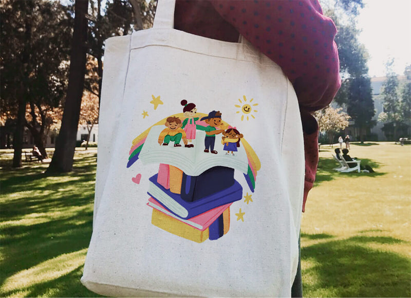 Tote bag with a colorful design of children and books in a park setting