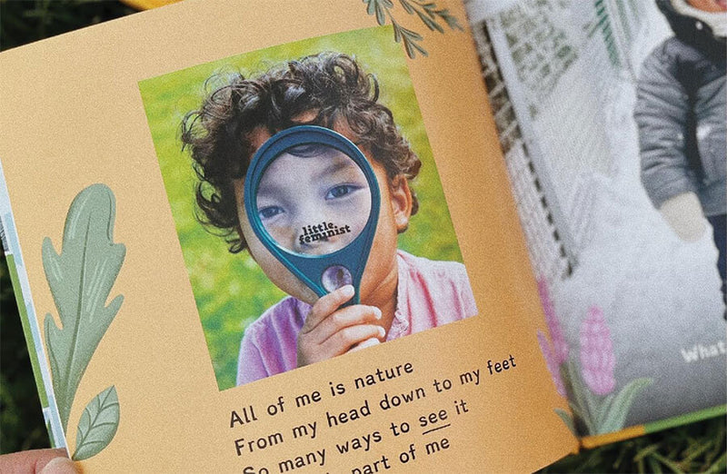Children's book open to a page with a child holding a magnifying glass and nature-themed text.