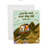 Greeting card with a mountain scene and a little dog riding a gondola. At the top the text says 'you're not over the hill (quite yet)'.