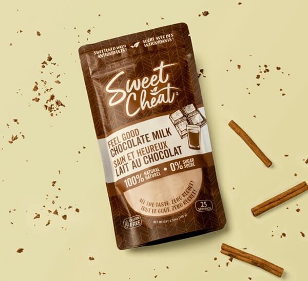 Sweet Cheat chocolate milk package on a beige background with chocolate pieces.