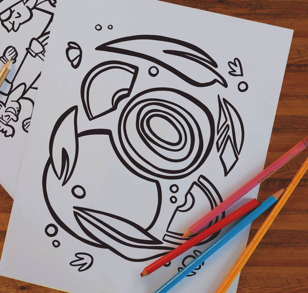 Coloring book page with a shark design and colored pencils on a wooden surface