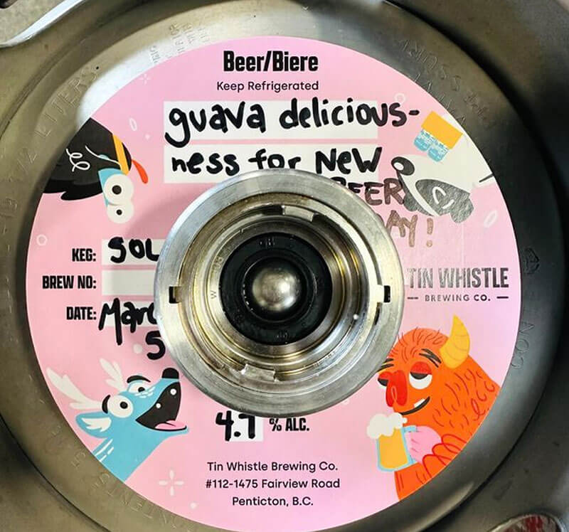 Beer keg cap with colorful label featuring cartoon characters and text.