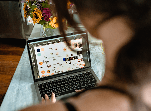 Person using a laptop with a floral arrangement in the background
